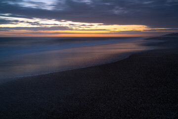 Fototapeta na wymiar Abendstimmung am Strand an der Nordsee nach Sonnenuntergang bei einem farbenfrohen Himmel