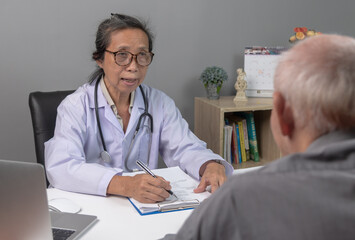 Asian woman doctor and senior elderly patient man patient. Healthcare and medicine concept.