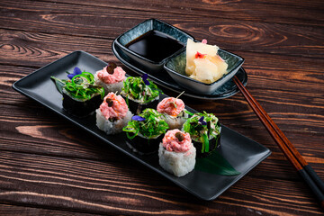 Japanese sushi roll set with salmon, tuna, cucumber, Philadelphia cheese, algae and microgreens.