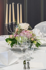 wedding decorations. Served wedding table with decorative natural flowers and. holiday details. flower arrangement, plates and candles in candlesticks, glasses