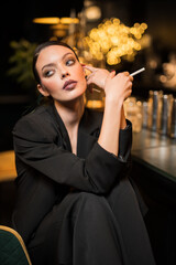 beautiful and sensual girl with cigarette near bar counter