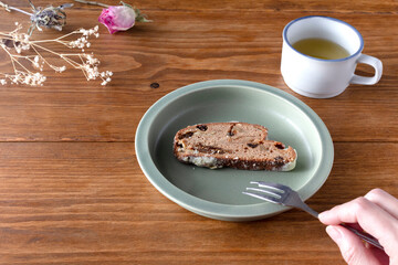 Eating tea and sliced cakes at break time, dried flower decorations such as hazel on brown wooden...