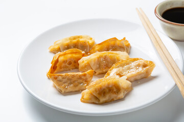 Close up of fried qyoza dumplings on white plate