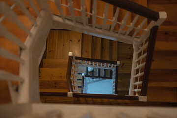 The view of the cat in the perspective of a wooden staircase, the view inside the house from top to...