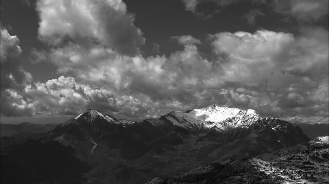 Black and white time-lapse of landscape with mountains and clouds