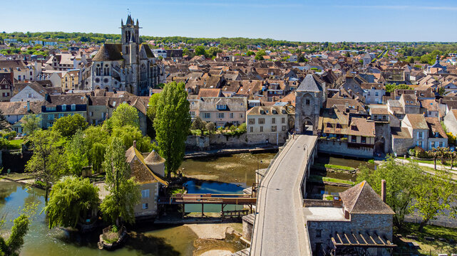 Aerial view of the medieval town of Moret-sur-Loing in Seine et Marne, France - Stone bridge spanning the river Loing towards the Burgundy Gate tower over the Moulin &agrave; Tan ("Tan water mill")