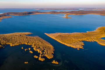 Masurian Lake District in Poland - beautifiul drone landscape, blue water, forest, autumn sunset...