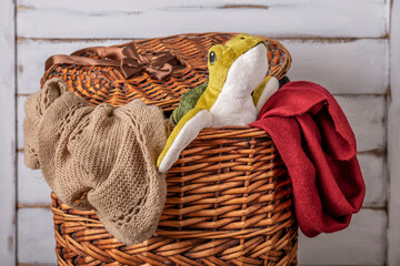 A stuffed turtle pops out of a wicker basket of dirty laundry