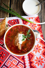 
Ukrainian borscht with sour cream. On a wooden background. Dinner