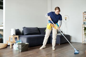 Cleaning service worker wiping floor with mop during her work in apartment