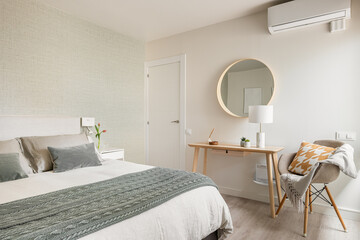 Spacious comfortable bedroom with a double bed, a cosmetic table and a mirror in an eco-boho style...