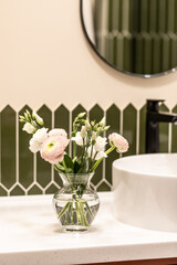 Bouquet of flowers in a glass vase on a light background. Eucalyptus and ranunculus.