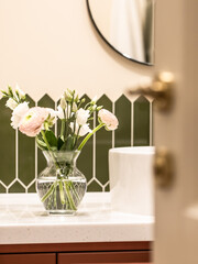 Bouquet of flowers in a glass vase on a light background. Eucalyptus and ranunculus.
