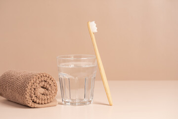 Bamboo toothbrush, towel and a glass of water. Eco-friendly items. Oral care. Biodegradable personal care products.