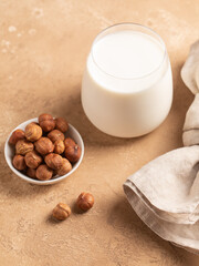 Hazelnuts, wooden spoon, nuts. Beige background.