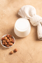 Hazelnuts, wooden spoon, nuts. Beige background.