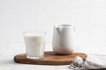 Glass of milk on a light background. Stylish kitchen background.