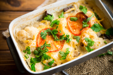 cauliflower baked with chicken fillet and mushrooms under cheese in a ceramic form