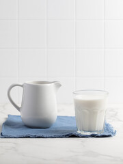Glass of milk on a light background. Stylish kitchen background.
