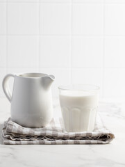 Glass of milk on a light background. Stylish kitchen background.