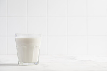 Fototapeta na wymiar Glass of milk on a light background. Stylish kitchen background.