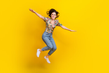 Full body size photo of attractive young woman flying hands wings crazy emotions traveler explore world isolated on yellow color background