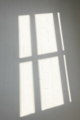 The silhouette of windows on the wall, created by sunlight that penetrated the room. Сlear lines.