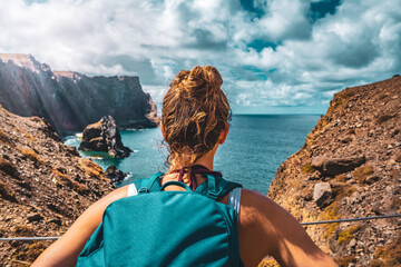 Sporty tourist enjoys picturesque view of the impressive cliffs of Madeira Island. São Lourenço,...