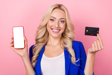 Photo of adorable shiny woman dressed blue blazer rising bank card device empty space isolated pink color background