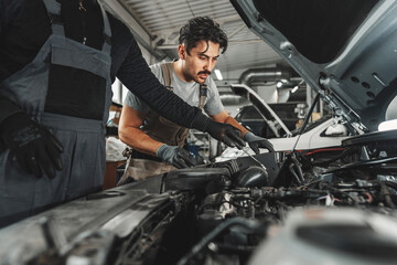 Mechanic examining car in auto car repair service center