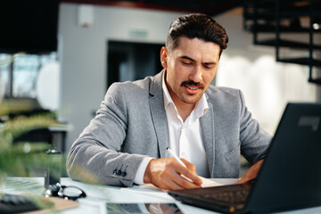 Obraz premium Young arab businessman working at the table in modern office