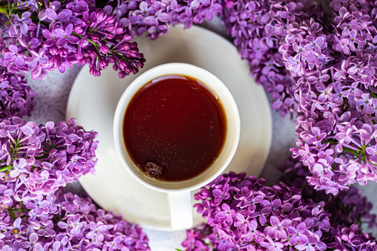 Top view of cup of tea and beautiful lilac flowers