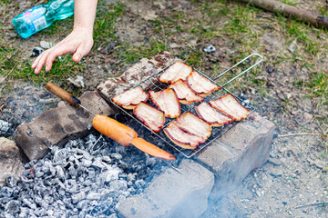 Obraz premium Barbecue in the forest of sausages and bacon.