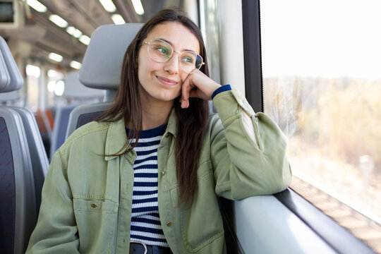Happy pensive woman looking away in bus