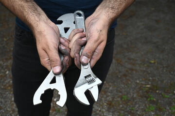 man's hand holding tools to repair a bicycle