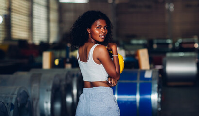 Portrait African American women worker standing in factory industry workplace. Female worker posing confidently while standing in factory workshop