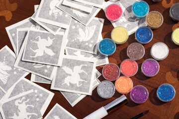 All the material ready on the table for making Shimmering sparkling glitter tattoo for children at a birthday party - obrazy, fototapety, plakaty