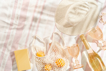 Summer beach rest concept background with sun hat, color wine glasses, champagne wine, fruits in...