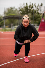 Fototapeta premium Fat Hispanic woman stretching for a workout outside