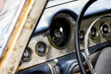 Classic american car dashboard. Steering wheel rim visible. Natural patina related to the age of...