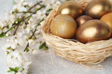 Easter eggs painted in gold in nest on table