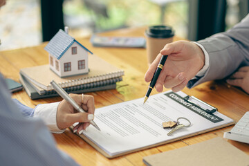 Real estate agent holding hands to client to sign agreement on buying or selling house in contract...