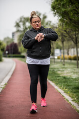 Fat woman using smart watch for her cardio workout