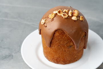 Ester cake with chocolate topping and nuts on gray background