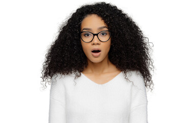 Shocked woman with frizzy hair and glasses, isolated on white background, surprised and stunned