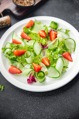 salad cucumber, strawberry, lettuce healthy meal food snack on the table copy space food background rustic top view keto or paleo diet veggie vegan or vegetarian food