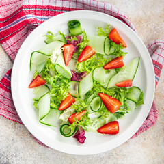 salad cucumber, strawberry, lettuce healthy meal food snack on the table copy space food background rustic top view keto or paleo diet veggie vegan or vegetarian food