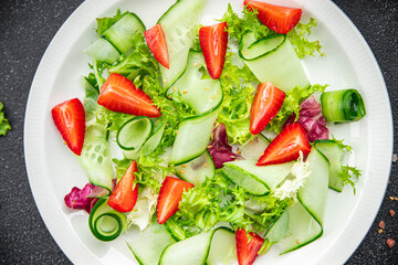 salad cucumber, strawberry, lettuce healthy meal food snack on the table copy space food background rustic top view keto or paleo diet veggie vegan or vegetarian food