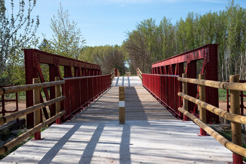 path to the forest with wooden and red metal bridge