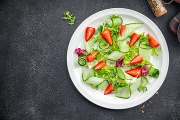 salad cucumber, strawberry, lettuce healthy meal food snack on the table copy space food background rustic top view keto or paleo diet veggie vegan or vegetarian food